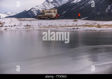 L'uomo prendendo foto di Camper Carrello con moto Touring in Canmore Foto Stock