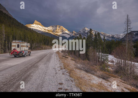 Camper Carrello con moto Touring nella parte anteriore della gamma della montagna tramonto Foto Stock