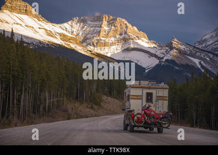 Camper Carrello con moto Touring nella parte anteriore della gamma della montagna tramonto Foto Stock