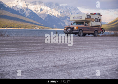 Camper Carrello con moto Touring di fronte al lago e montagne Foto Stock