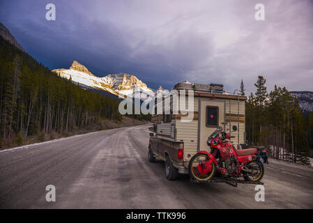 Camper Carrello con moto Touring nella parte anteriore della gamma della montagna tramonto Foto Stock