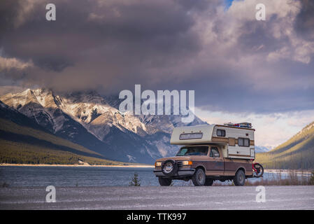 Camper Carrello con moto Touring di fronte al lago e montagne Foto Stock