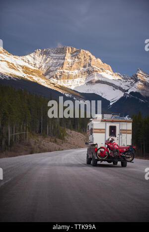 Camper Carrello con moto Touring nella parte anteriore della gamma della montagna tramonto Foto Stock