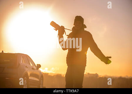 L'uomo prendendo fotografie della skyline della città al tramonto Foto Stock