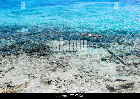 Elevato angolo di visione della donna spensierata galleggiante sul lago Foto Stock