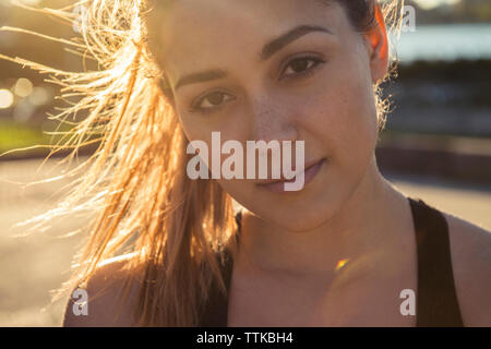 Close-up verticale di fiducioso giovane donna durante la giornata di sole in città Foto Stock