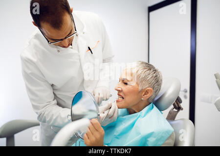 Dentista controllo donna di denti in clinica Foto Stock