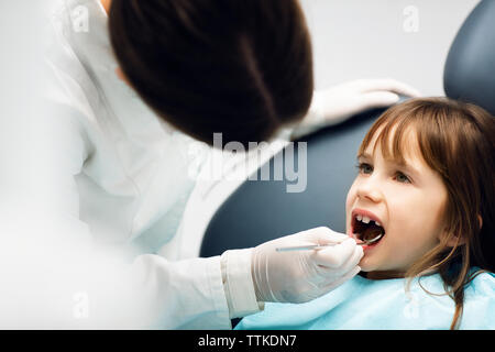 Dentista controllando la ragazza denti in clinica Foto Stock