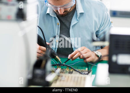 Serio lavoro tecnico a tavola in industria elettronica Foto Stock