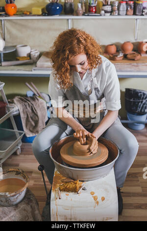 Angolo di alta vista di certi potter forma di stampaggio di argilla in officina Foto Stock