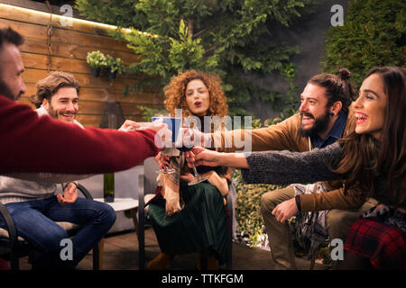 Allegro amici bevande di tostatura in festa a backyard Foto Stock