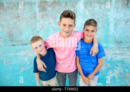 Tre fratelli guarda verso la telecamera per un sorridente ritratto Foto Stock