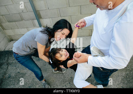 Padre gioca con la figlia dei bimbi mentre la madre si unisce in Foto Stock