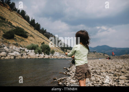 Vista laterale della ragazza la pesca in fiume e al Parco Nazionale di Yellowstone Foto Stock