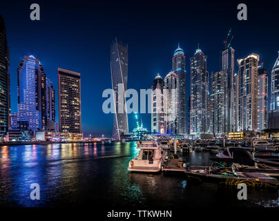 Fiume e illuminato cityscape contro il cielo blu di notte Foto Stock