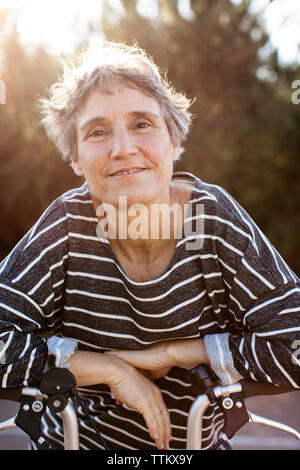 Ritratto di donna sorridente mentre si sta in piedi sul giorno di sole Foto Stock