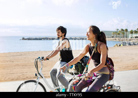 Giovane sportivo equitazione biciclette su strada dalla spiaggia Foto Stock