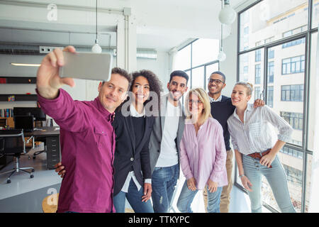 Felice la gente di affari tenendo selfie dalla finestra di office Foto Stock