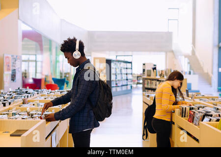 studenti che scelgono libri in biblioteca Foto Stock