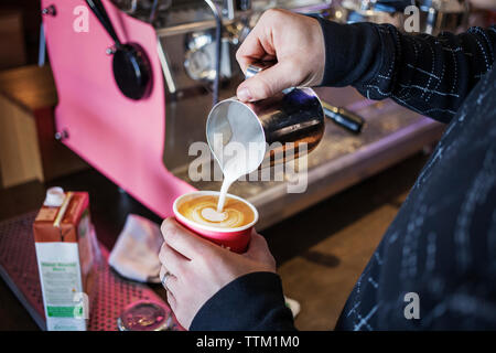 Immagine ritagliata della donna di bollitore per caffè Foto Stock