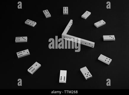 L'effetto domino in forma di orologio su sfondo nero Foto Stock