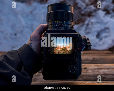 Ritagliato mano che tiene la fotocamera digitale visualizzazione foto di formazioni rocciose presso il desert Foto Stock