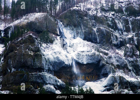 Inverno cascata su rocce giganti della neve e del ghiaccio coperto Foto Stock