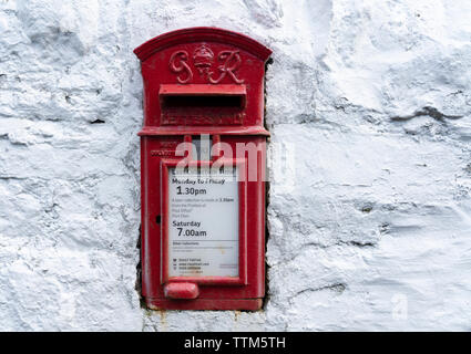 Dettaglio di un tradizionale vecchio rosso postbox sul muro bianco Foto Stock