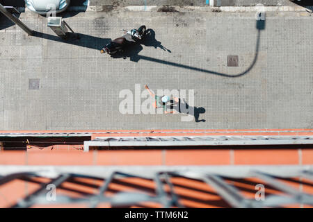 Elevato angolo di visione della donna lo skateboard su strada Foto Stock