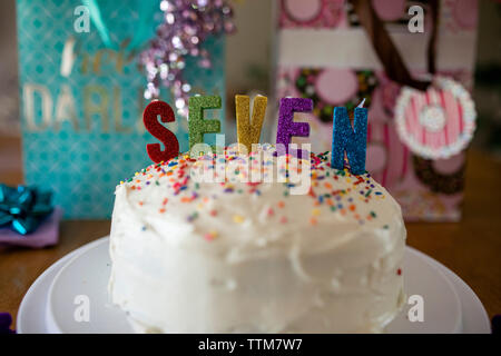 Close-up di candele colorate sulla torta di compleanno a casa Foto Stock