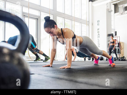 Il livello superficiale di atleti facendo push-up in palestra crossfit Foto Stock