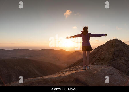 20 30 anni ragazza bionda ammirando il tramonto dalla cima di un vulcano Foto Stock