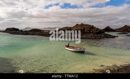 Barca e paesaggio vulcanico al piccolo porto di Isola di Lobos Fuerteventura Isole Canarie Foto Stock