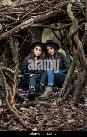 Ritratto di donna amici seduti in mezzo a radici nella Foresta di Epping Foto Stock