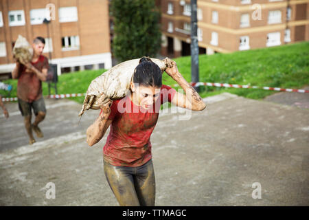 Elevato angolo di visione dei partecipanti trasportano contrappeso e passaggi di arrampicata durante la gara Foto Stock