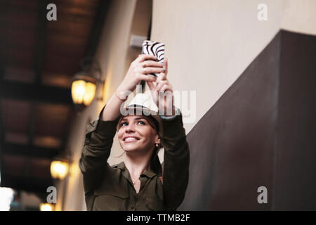 Giovane turista femminile in Panama tenendo Autoritratto con il telefono cellulare Foto Stock
