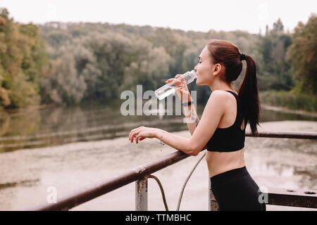 Pareggiatore femmina acqua potabile mentre si sta in piedi sul molo sul lago di garda Foto Stock