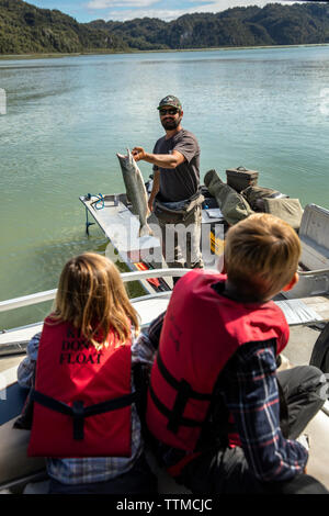 Stati Uniti d'America, Alaska, Redoubt Bay, grande fiume lago, un pescatore di mostrare la sua cattura Foto Stock
