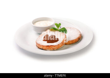 Frittelle di formaggio su una piastra con panna acida, isolato su sfondo bianco Foto Stock
