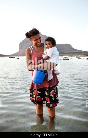 Maurizio, una madre e suo figlio a caccia di lumache con la bassa marea, Baie du Cap Foto Stock