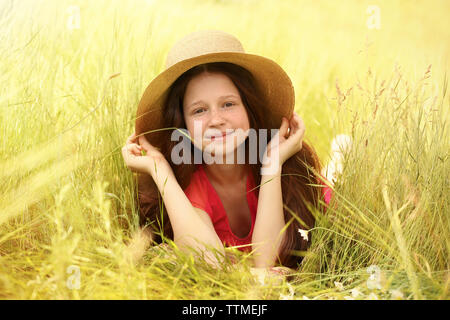 Ragazza dolce in prato selvaggio con fiori di primavera Foto Stock