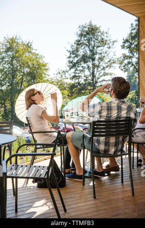 Stati Uniti d'America, Oregon, Willamette Valley, un gruppo di viaggiatori godere di alcuni vini e la conversazione al di fuori nel patio a Sokol Blosser Winery, Dayton Foto Stock