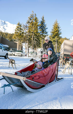 Stati Uniti d'America, Oregon, piegare una famiglia in posa per una foto prima di uscire sulla loro sled dog ride a Mt. Corso di laurea Foto Stock