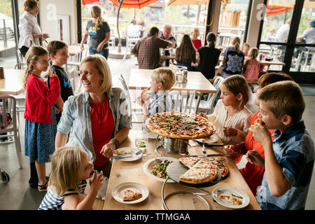 Stati Uniti d'America, Oregon, piegare, Pacific Pizza e birra, la donna e i bambini a mangiare la pizza Foto Stock