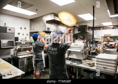 Stati Uniti d'America, Oregon, piegare, Pacific Pizza e birra, la pizza chef tossing impasto Foto Stock