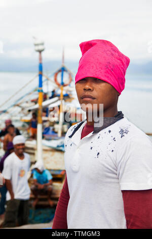 Filippine, Palawan Puerto Princesa, ritratto di un pescatore nella parte anteriore della barca Kivea nella città Area portuale Foto Stock