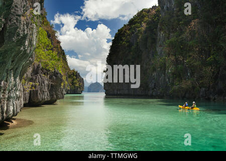 Filippine, Palawan El Nido, Miniloc Island, turisti kayak attraverso le acque cristalline della grande laguna sulla Miniloc isola situata nella baia di Bacuit ho Foto Stock