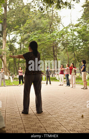 Il Vietnam, Hanoi, donne di allungamento e di esercitare la mattina presto, il Lago Hoan Kiem Foto Stock