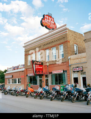 USA, Wyoming, motociclette in fila parcheggiate fuori dall'Irma Restaurant e dall'hotel, Cody Foto Stock