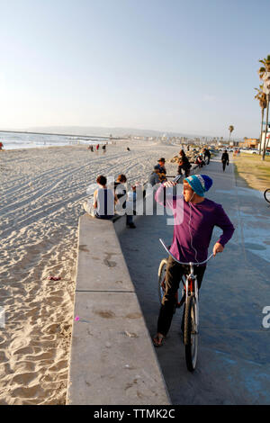 Stati Uniti, California, San Diego, individui resto lungo la passerella a Ocean Beach Foto Stock